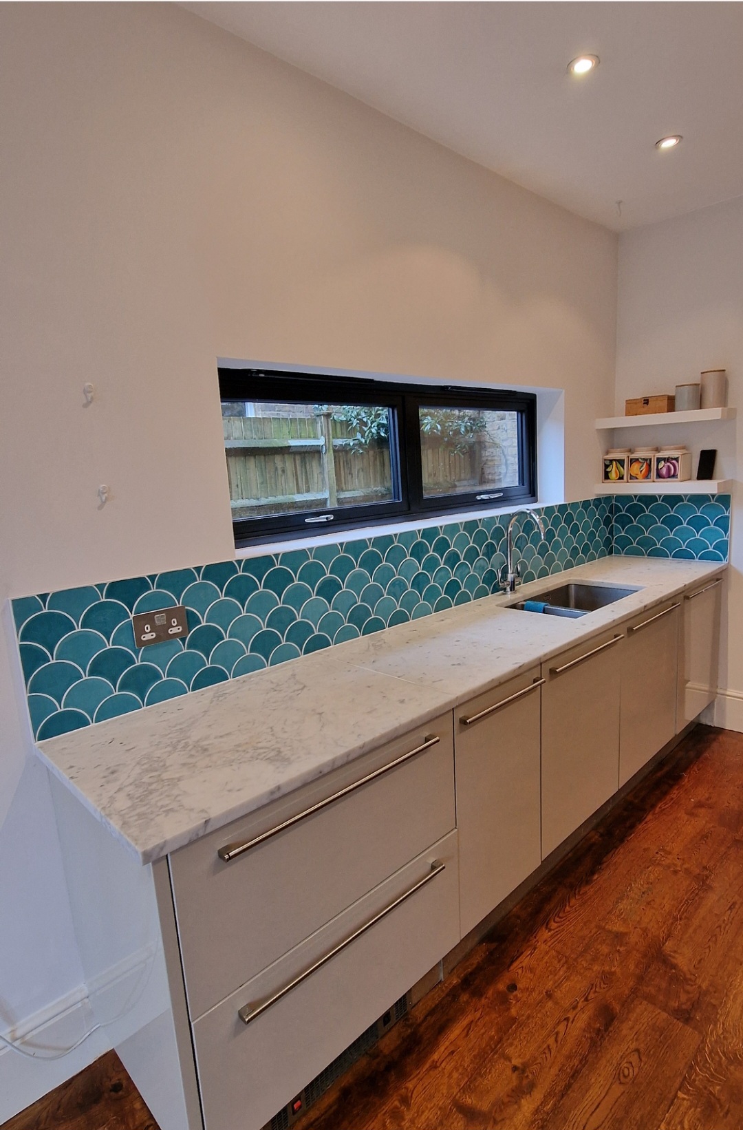 Completed kitchen with teal tiled splashback